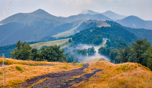Mountain hills after the rain. Misty summer scene of Krasna range with old country road. Splendid morning view of foggy Carpathian mountains, Ukraine, Europe. Traveling concept background..