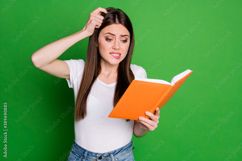 Portrait of pretty confused young lady read book touch head wear casual t-shirt isolated on green background Portrait of pretty confused young lady read book touch head wear casual t-shirt isolated on green background
