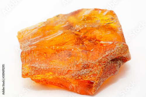A piece of transparent yellow amber with inclusions on a white background. Natural fossil fossilized resin. Crystal. Colored mineral copal. Sun stone. Material for jewelry. Ancient tar