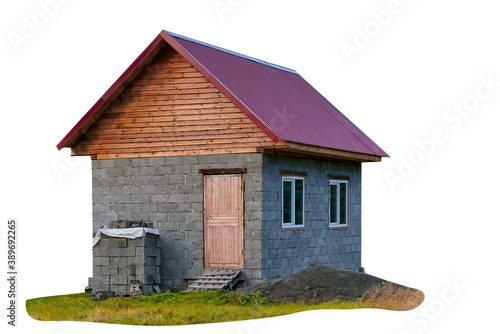 A small one-story house under construction from cinder blocks with a metal roof isolate on a white background.