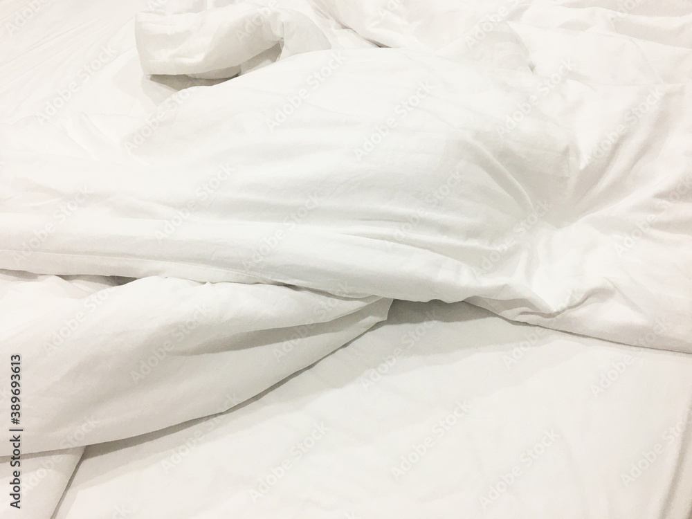 after waking up in the​ morning. The crinkle blanket on the bed in the hotel with the sun​light​ on​ the​ blanket