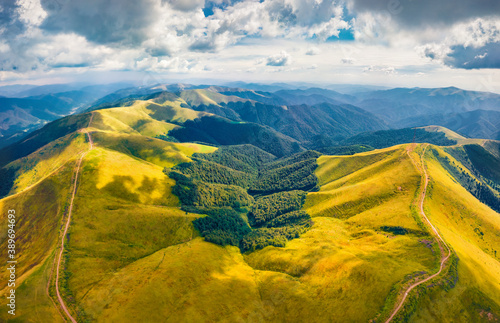 Amazing summer view from flying drone of Krasna range with old country road. Superb morning view of green Carpathian mountains, Ukraine, Europe. Traveling concept background.