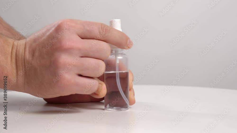 hands untwist the spray cap on a mini bottle of disinfectant. antiseptic. hands untwist the spray cap on a mini bottle of disinfectant. antiseptic.