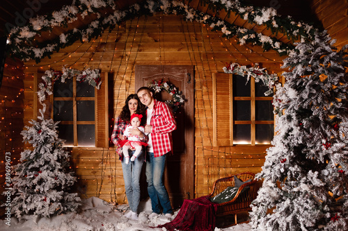 Mom and dad pose with their charming little daughter in decorated christmas studio. New Year photo session. © Andriy Medvediuk