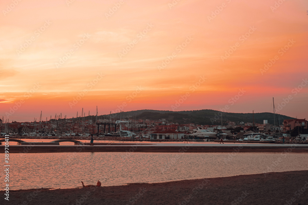 Sunset in Croatia. Evening city of Vodice. The sun sets into the sea.