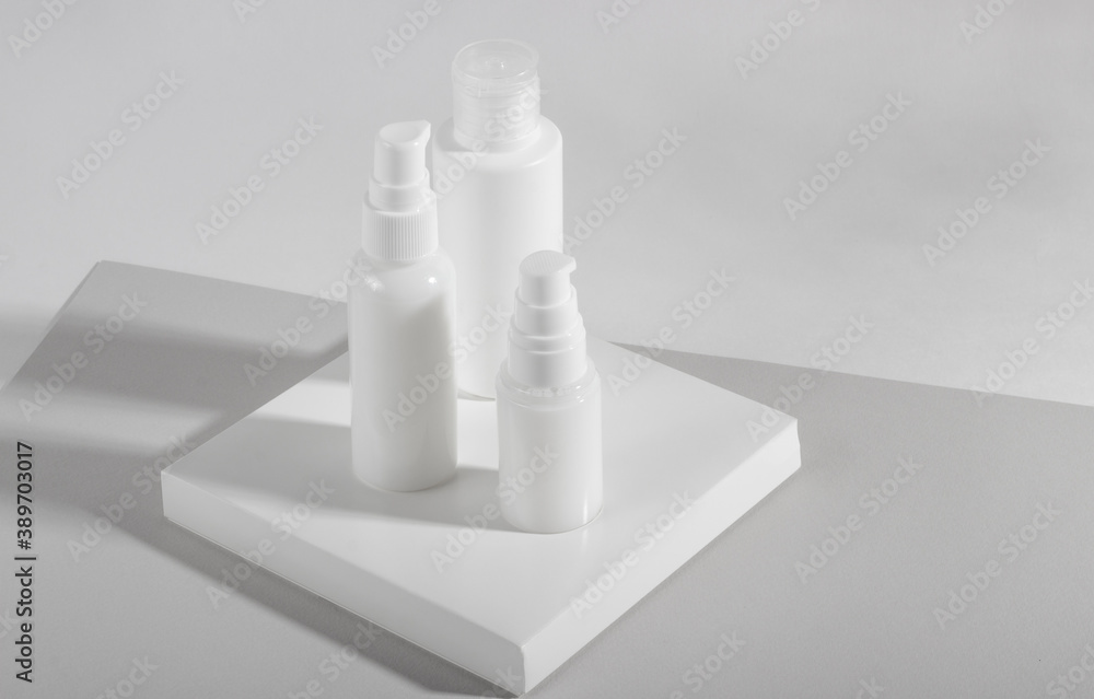 Set of white cosmetic bottles and jars with hard shadows. Home and beauty salon care concept Set of white cosmetic bottles and jars with hard shadows. Home and beauty salon care concept