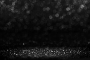 Black friday bokeh background. Elegant dark blur layout design. Silver and black glitter place on table with spotlight. Luxury abstract banner with copyspace.