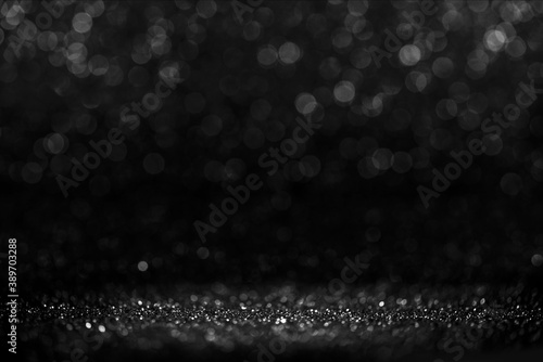 Black friday bokeh background. Elegant dark blur layout design. Silver and black glitter place on table with spotlight. Luxury abstract banner with copyspace.