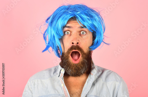 Surprised man in color wig. Surprised bearded man looking at camera. Portrait of surprised man. Isolated. Wig. Colorfull hair. Emotions.