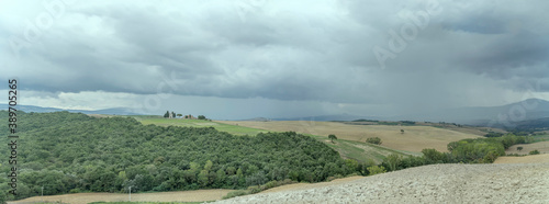stormy sky over Tuscan hilly green landscape, near San Quirico, Siena, Italy
