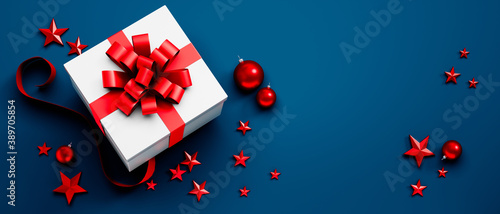 Fotografie White Gift Box with red Bow on blue Background