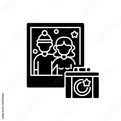 Winter photoshoot black glyph icon. Family festive photo. Couple portrait. Wife and husband pose for shot. Romantic Christmas activity. Silhouette symbol on white space. Vector isolated illustration