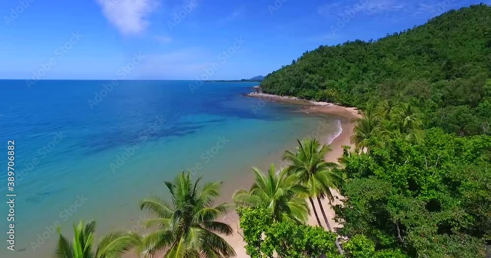Drone flying along an empty tropical beach on a clear blue sunny day with palm trees. Drone flying along an empty tropical beach on a clear blue sunny day with palm trees.
