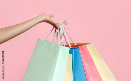 Female hand of young african american woman holds a lot of paper colored bags with purchases