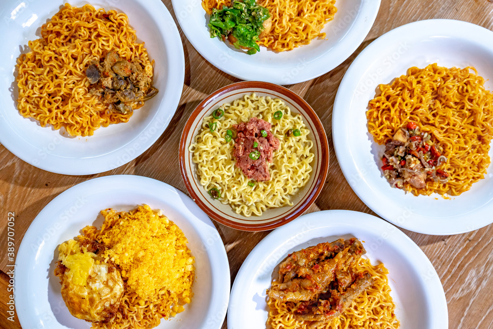 Indonesian instant noodles are served in white plates and arranged in such a way on the table. Indonesian instant noodles are served in white plates and arranged in such a way on the table.