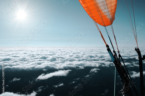 Paragliding above the clouds. Outdoor aerial adventure photography, extreme sports.