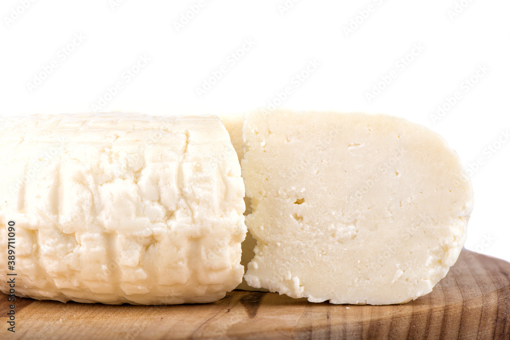 Close-up of a cut of soft cheese on a cutting board.