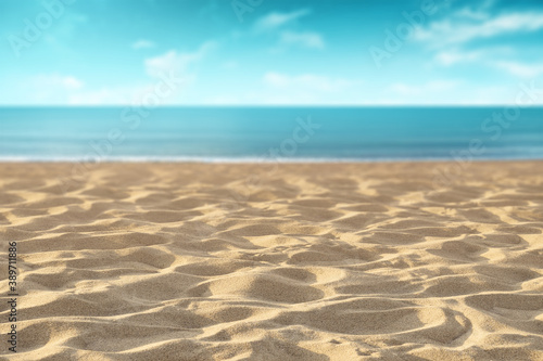 Sand on the beach with an unfocused view of the sea in the background on a summer day