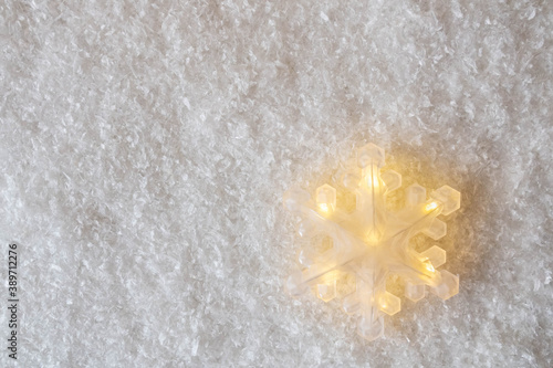Big shining snowflake decoration on snow imitation background