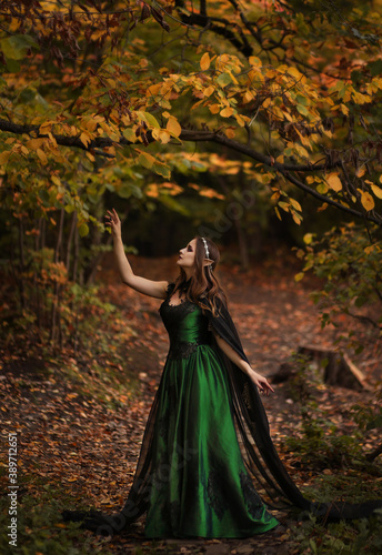 Elf in green dress in autumn forest