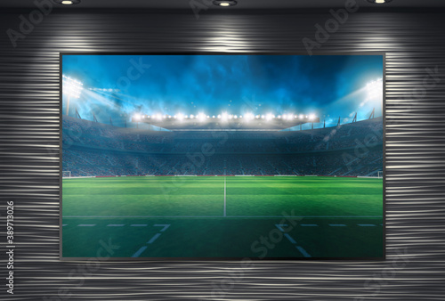 Watching a soccer event on a large TV wall mounted and illuminated by spotlights