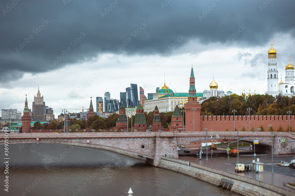 View of the kremlin's part in and the Great zamoskvoretsky bridge with traffic from cars in cloudy weather.