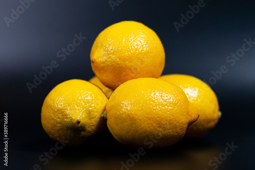 A group of fresh lemons are laid out in a pyramid shape.