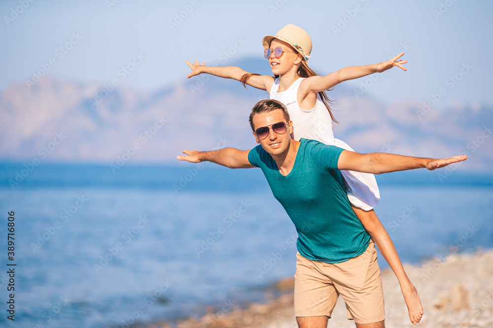 Little girl and happy dad having fun during beach vacation Little girl and happy dad having fun during beach vacation