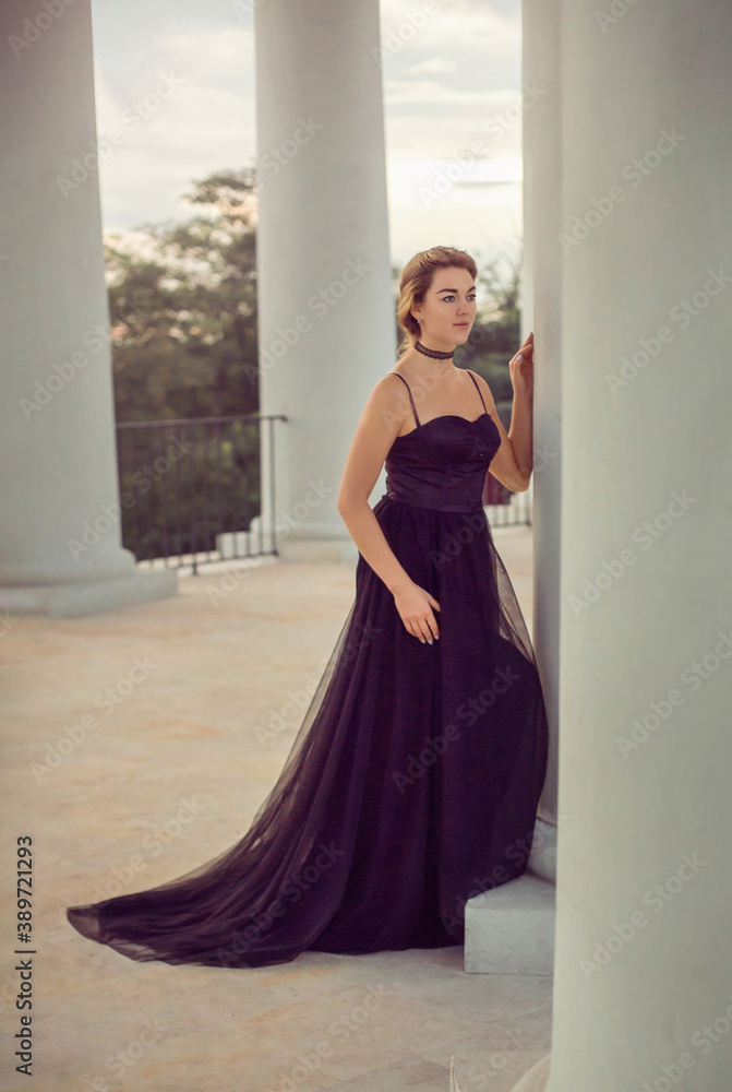 A girl in a long black dress walks through the old city
A girl in a long black dress walks through the old city