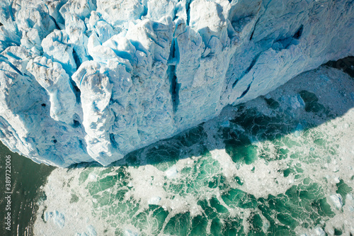Water churns below the towering face of a Glacier in Alaska just after a massive calving event. 