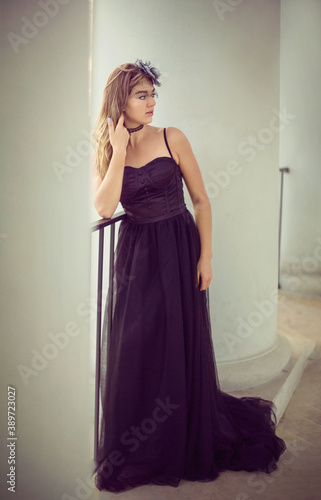 
A girl in a long black dress walks through the old city