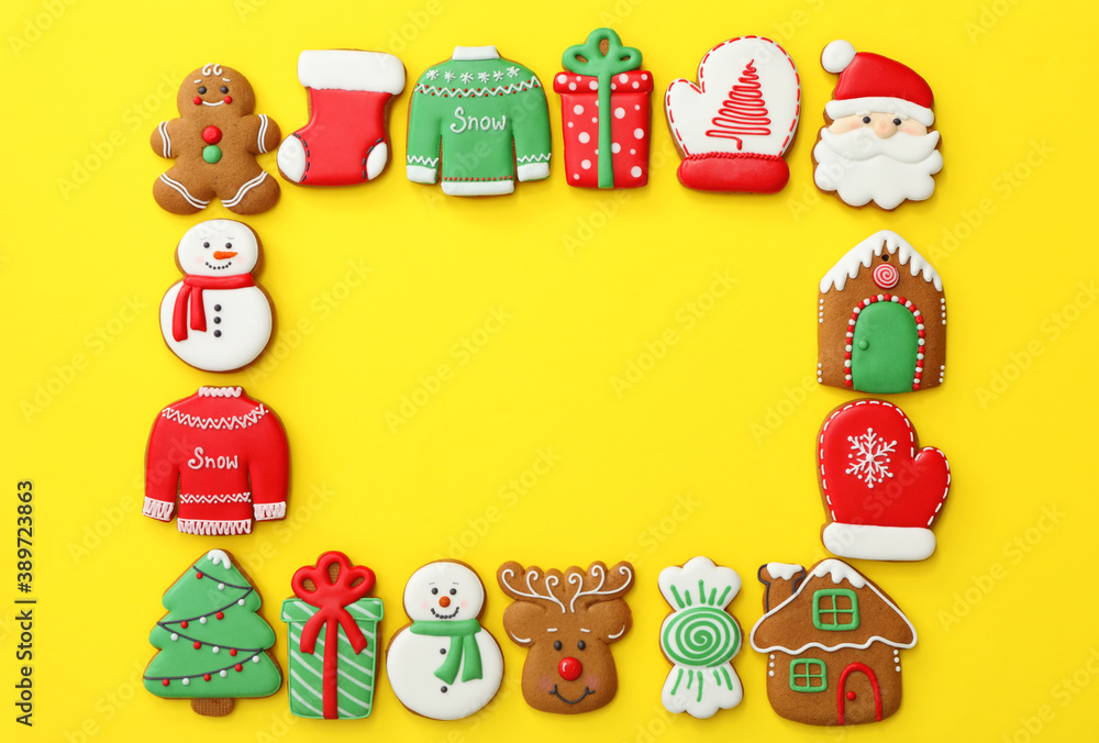 Naklejka premium Frame made with different Christmas gingerbread cookies on yellow background, flat lay. Space for text
