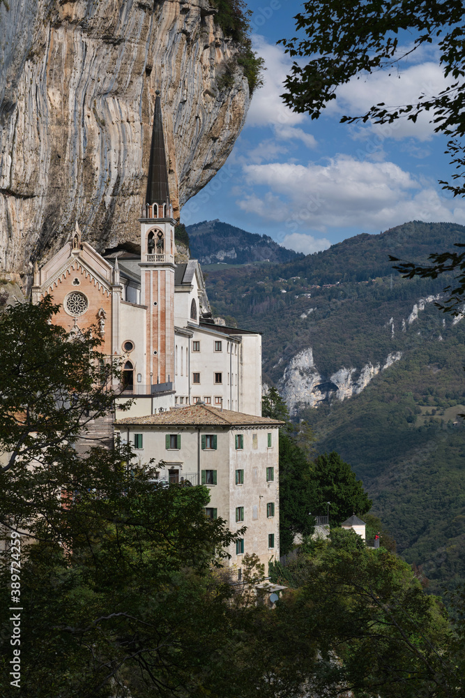 View of the church on a steep cliff. Italian church at high altitude in the Alps. The sanctuary is high in the cliffs of Italy. The unique Sanctuary Madonna della Corona church in the rock.