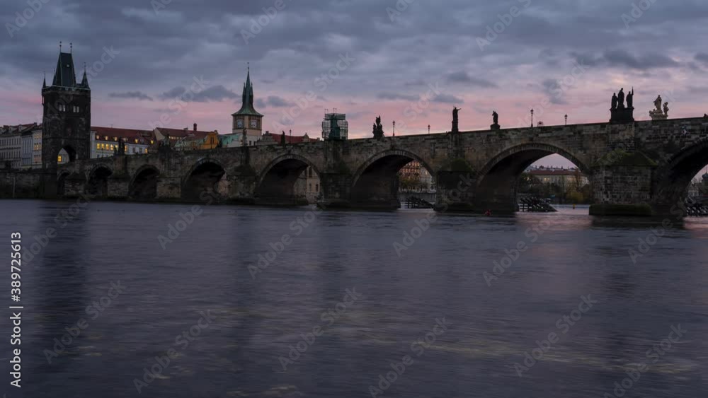 time lapse of the Charles Bridge from the 14th century on the flowing river Vltava and the movement of colored clouds at sunset in the old town of Prague in the Czech Republic at dusk time lapse of the Charles Bridge from the 14th century on the flowing river Vltava and the movement of colored clouds at sunset in the old town of Prague in the Czech Republic at dusk