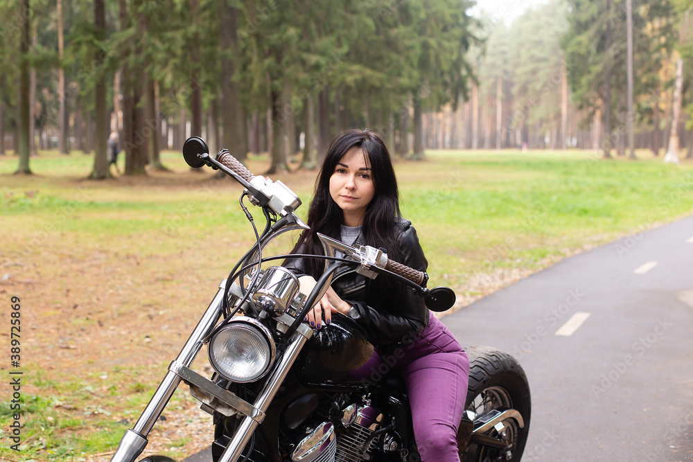 Obraz premium beautiful brunette on a motorcycle on the track