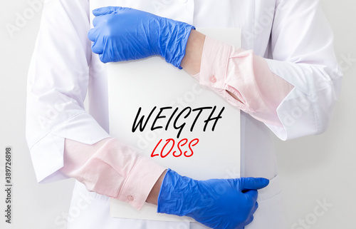 Weight loss inscription on paper in docotor hands. Health care and dieting photo