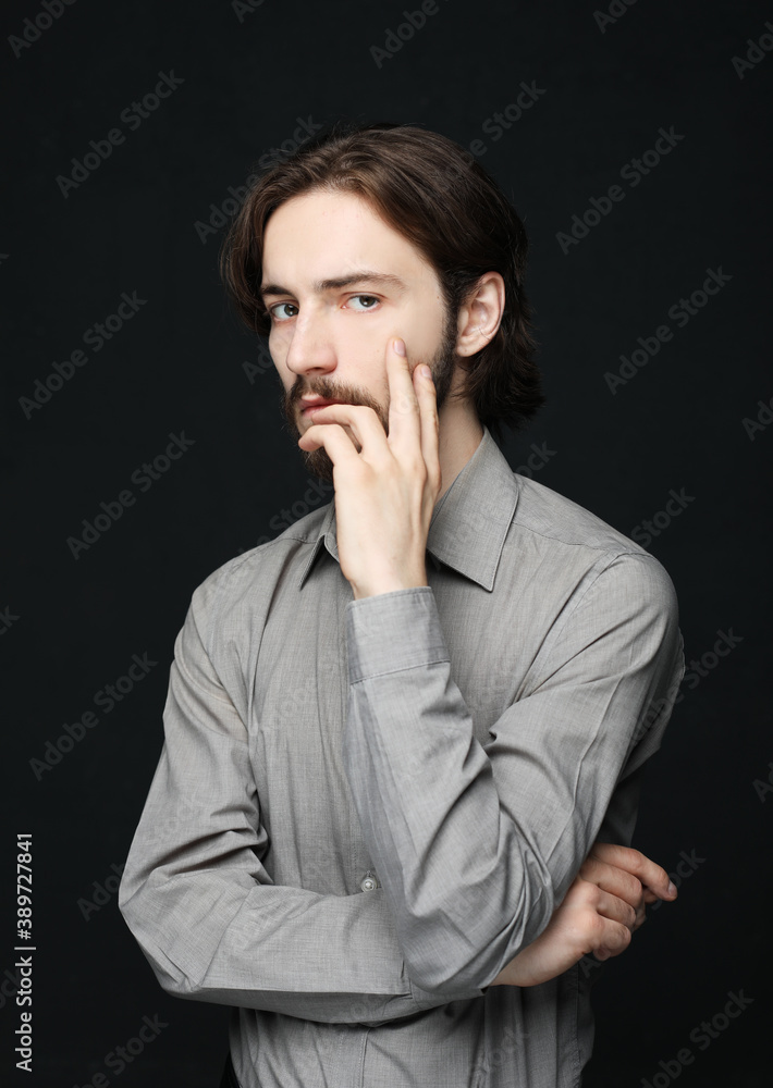 unhappy man touching his forehead over black background unhappy man touching his forehead over black background