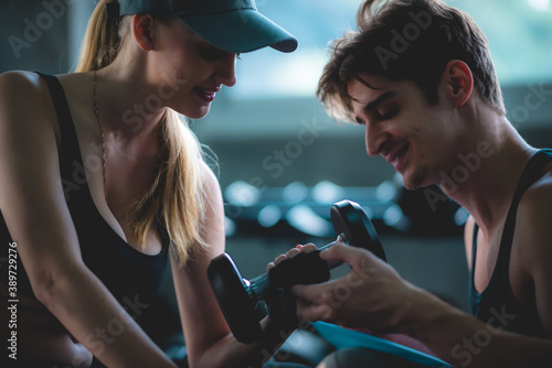 Personal trainer helping woman exercising in the sport gym