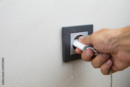 Wallpaper Mural close up photo revealing that a person is plugging in or unplugging to charge/discharge of a battery Torontodigital.ca