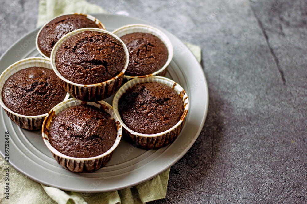 Homemade gluten-free muffins with chocolate close-up. Gluten-free flour cupcakes with chocolate on a green plate with a napkin on a dark table. Low Carb Sugar Free Cupcakes Homemade gluten-free muffins with chocolate close-up. Gluten-free flour cupcakes with chocolate on a green plate with a napkin on a dark table. Low Carb Sugar Free Cupcakes