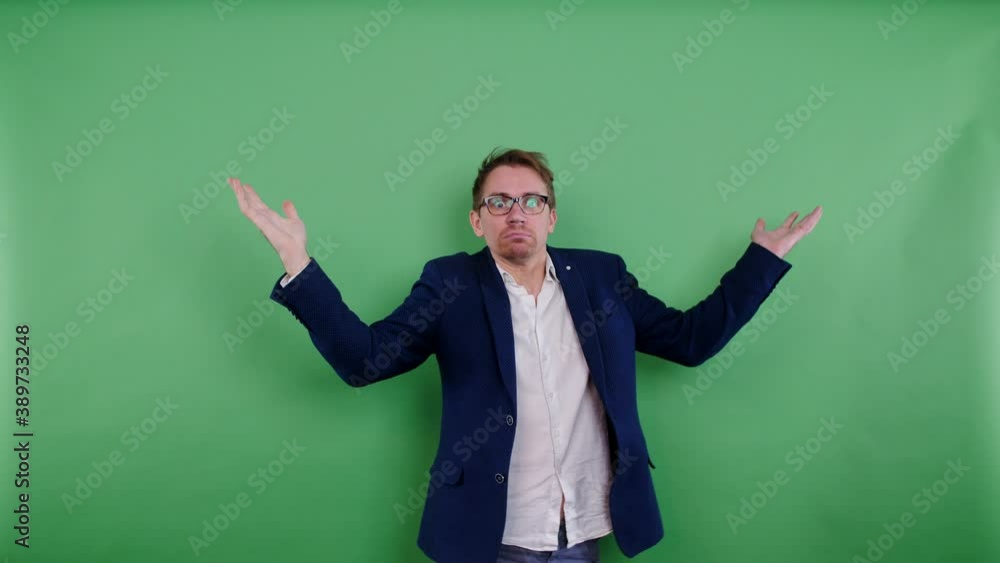 Young business man doubting and shrugging shoulders. Lost and has no idea, don't have an answer. Dumb, funny, clueless and confused, looking around searching. Isolated on green screen background Young business man doubting and shrugging shoulders. Lost and has no idea, don't have an answer. Dumb, funny, clueless and confused, looking around searching. Isolated on green screen background