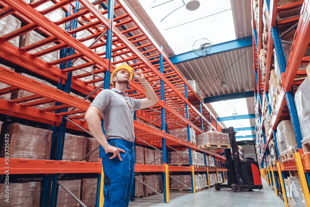 Logistics worker standing in high bay warehouse