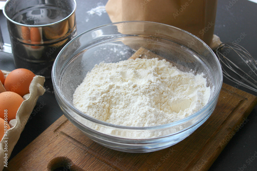 A bowl of flour and egg on the kitchen table.Preparation of home-made dough. Baking ingredients