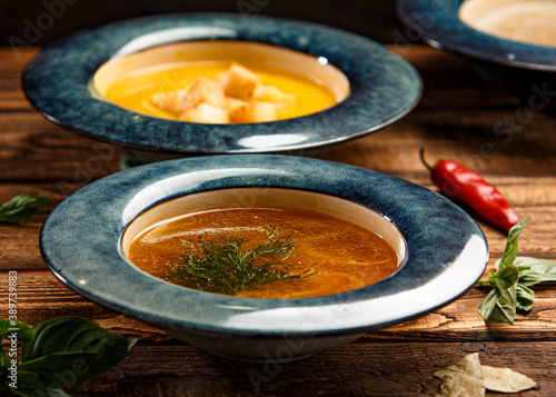 chicken broth with dill on wooden background 
