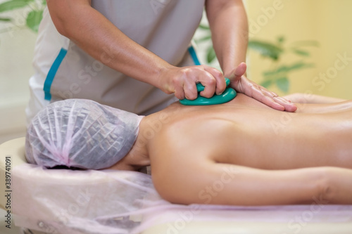 Massage therapist massaging young woman. Vacuum massage