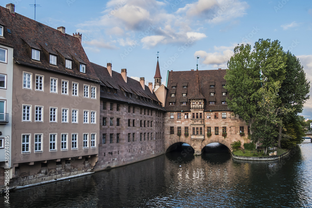 Ancient Nurnberg Heilig Geist Spital building (Hospital of the Holy Ghost, 1339) over Pegnitz river. View from the Bridge on the River Pegnitz. Nuremberg, Germany.