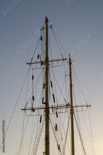 Masts of an old ship against a blue sky.