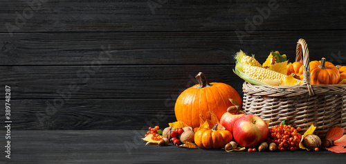 Happy Thanksgiving Day  banner design. Composition with vegetables  fruits and autumn leaves on black wooden table  space for text