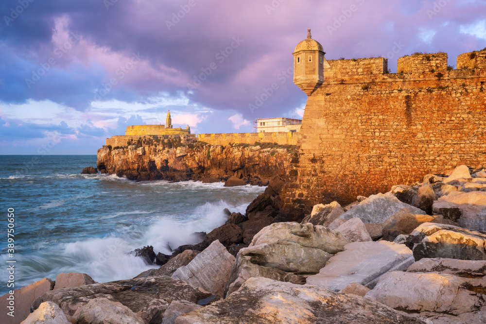 Peniche Fortress at sunset with beautiful golden light with sea waves crashing on the rocks, in Portugal