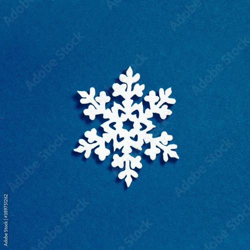Christmas snowflake decoration on blue background. Minimalistic Christmas concept